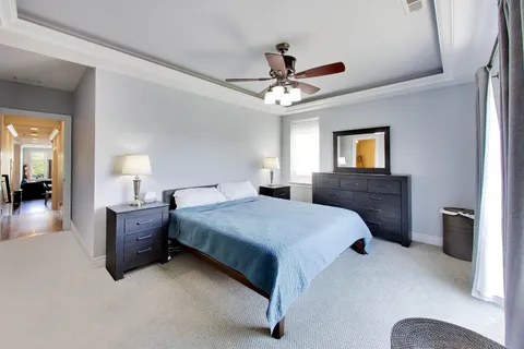 a bedroom with a large bed and a chandelier