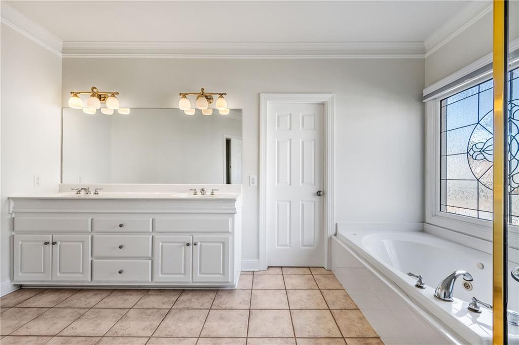 2013 Cockrell Run Northwest Kennesaw, GA 30152 - Photo 34 of 69 a spacious bathroom with a granite countertop sink a mirror and a bathtub