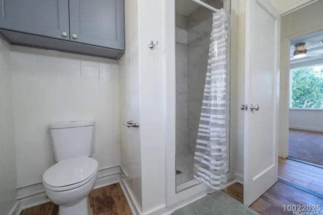 a bathroom with a toilet and a shower