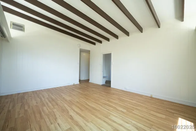 a view of a room with wooden floor and white walls