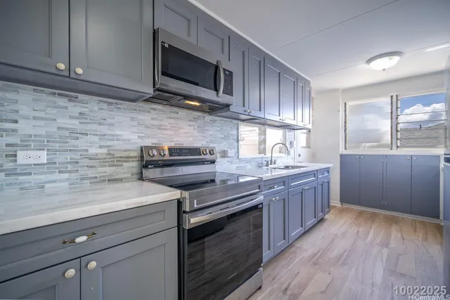 a kitchen with stainless steel appliances granite countertop wooden cabinets a stove a sink and dishwasher