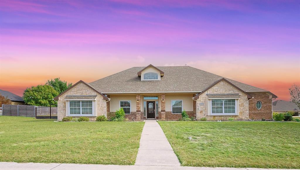 View of front of house with stone siding, roof with shingles, and covered porch