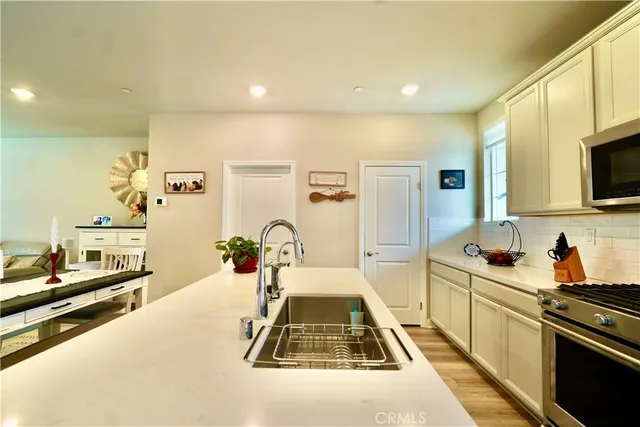 a very nice looking kitchen with a large counter top space and stainless steel appliances