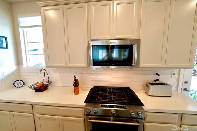 a kitchen with microwave cabinets and a stove top oven