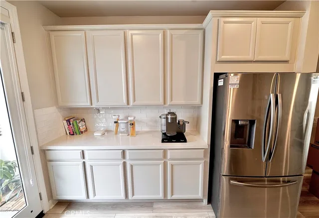 a kitchen with white cabinets and refrigerator