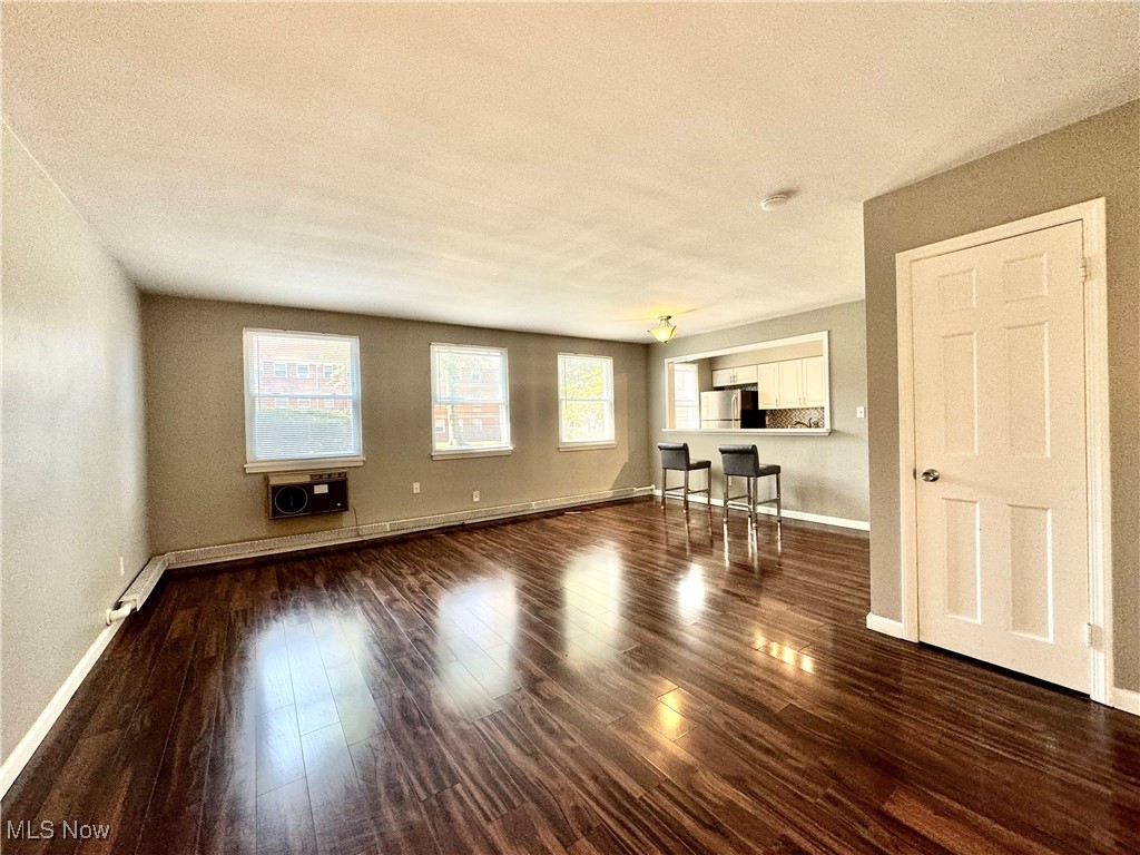 13805 Cedar Road, Unit 103C Cleveland, OH 44118 - Photo 2 of 18 Unfurnished living room featuring dark wood-style flooring and a textured ceiling