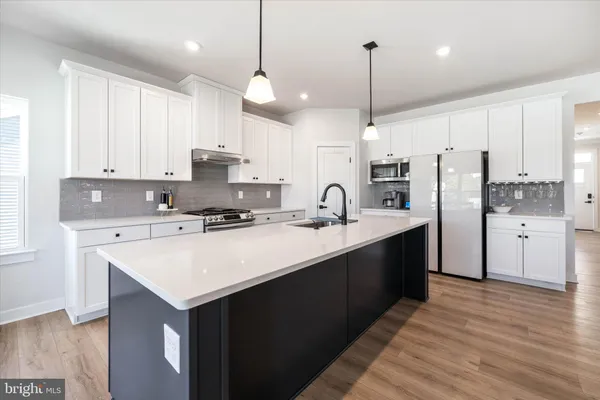 a kitchen with stainless steel appliances granite countertop a sink stove and cabinets