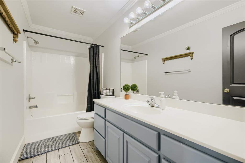 603 Ash Street Pilot Point, TX 76258 - Photo 23 of 28 Bathroom featuring a light blue vanity with integrated sink, white countertop, and a full-width mirror