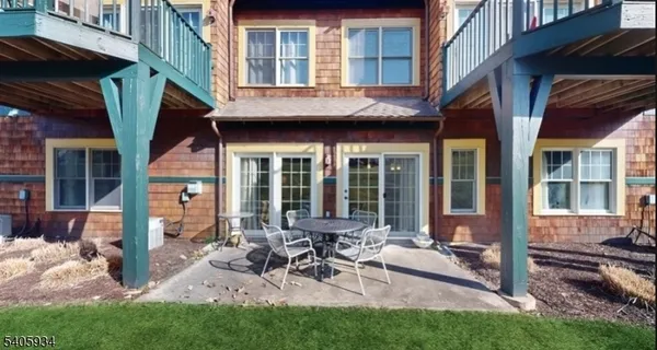 a view of a house with a patio and a yard