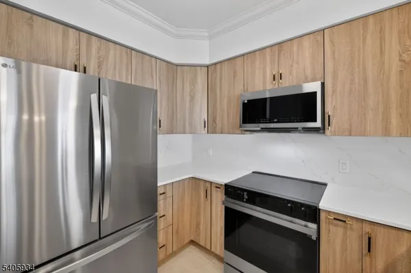 a kitchen with granite countertop a refrigerator stove and microwave