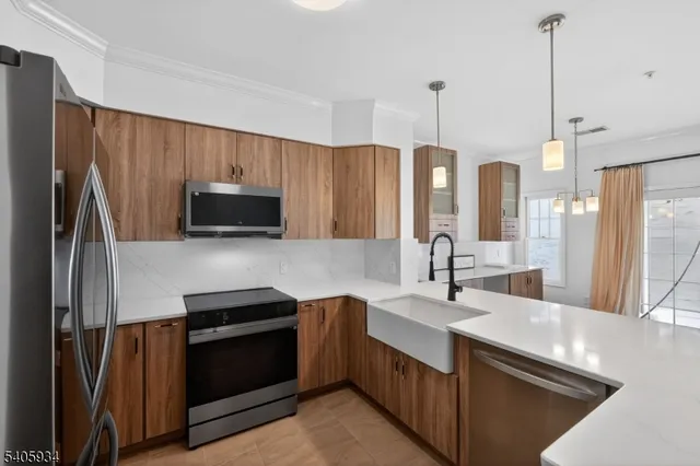 a kitchen with stainless steel appliances a sink stove and refrigerator