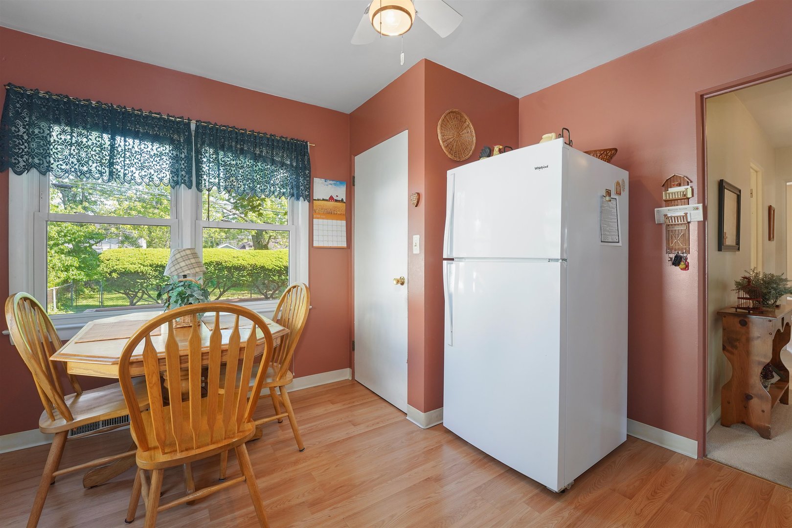 205 East Burlington Street Riverside, IL 60546 - Photo 10 of 19 a white refrigerator freezer sitting in a kitchen with large window and wooden floor