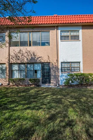 a view of a house with a yard next to a lake