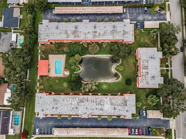 an aerial view of a residential houses with outdoor space and lake view
