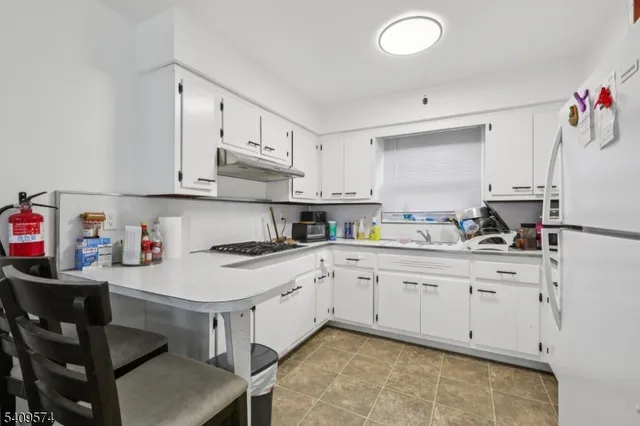a kitchen with granite countertop white cabinets and stainless steel appliances
