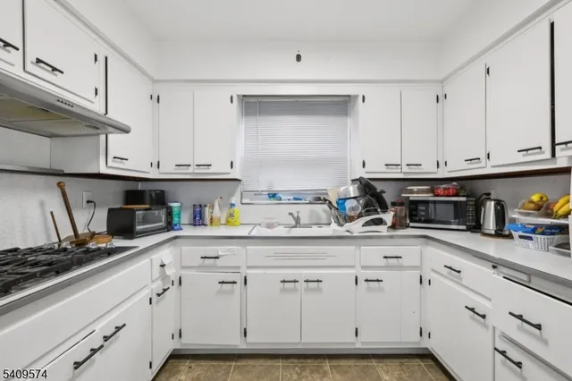 a kitchen that has a lot of cabinets in it and appliances