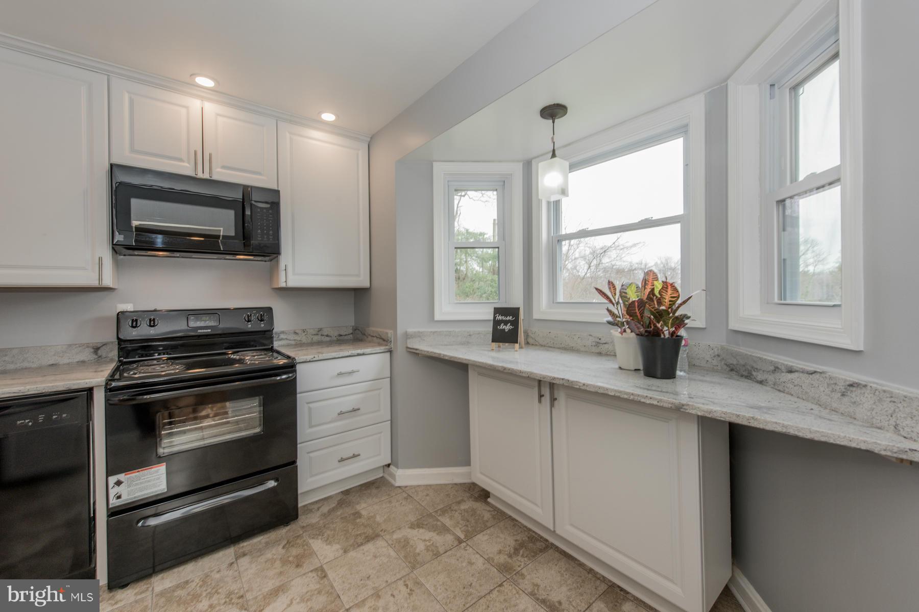 11019 Oakwood Street Silver Spring, MD 20901 - Photo 11 of 30 a kitchen with stainless steel appliances granite countertop a sink a stove and a microwave