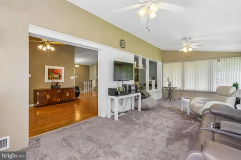a dining room with furniture a chandelier and wooden floor