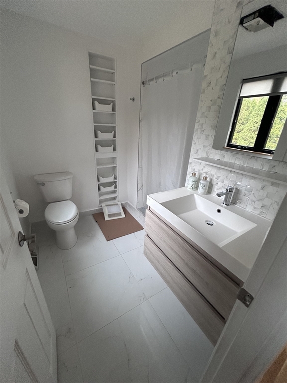 44 Marla Circle Newton, MA 02459 - Photo 12 of 23 a bathroom with a sink a toilet and vanity