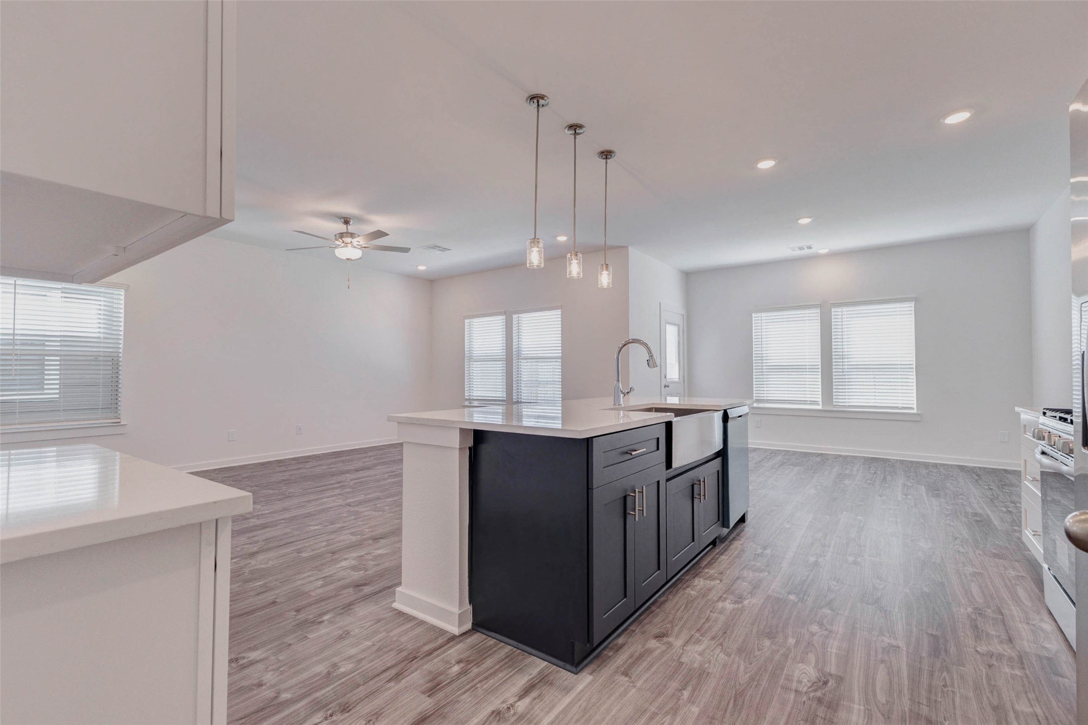 1038 Elsinore Drive Rosharon, TX 77583 - Photo 9 of 27 This view from the kitchen island showcases the expansive open-concept living area beyond. The layout allows natural light from multiple windows to flow freely throughout the space, enhancing the bright and inviting atmosphere. With wide-plank flooring, modern lighting, and an open design that connects cooking, dining, and relaxation spaces, the home offers a comfortable environment ideal for both everyday living and entertaining guests.