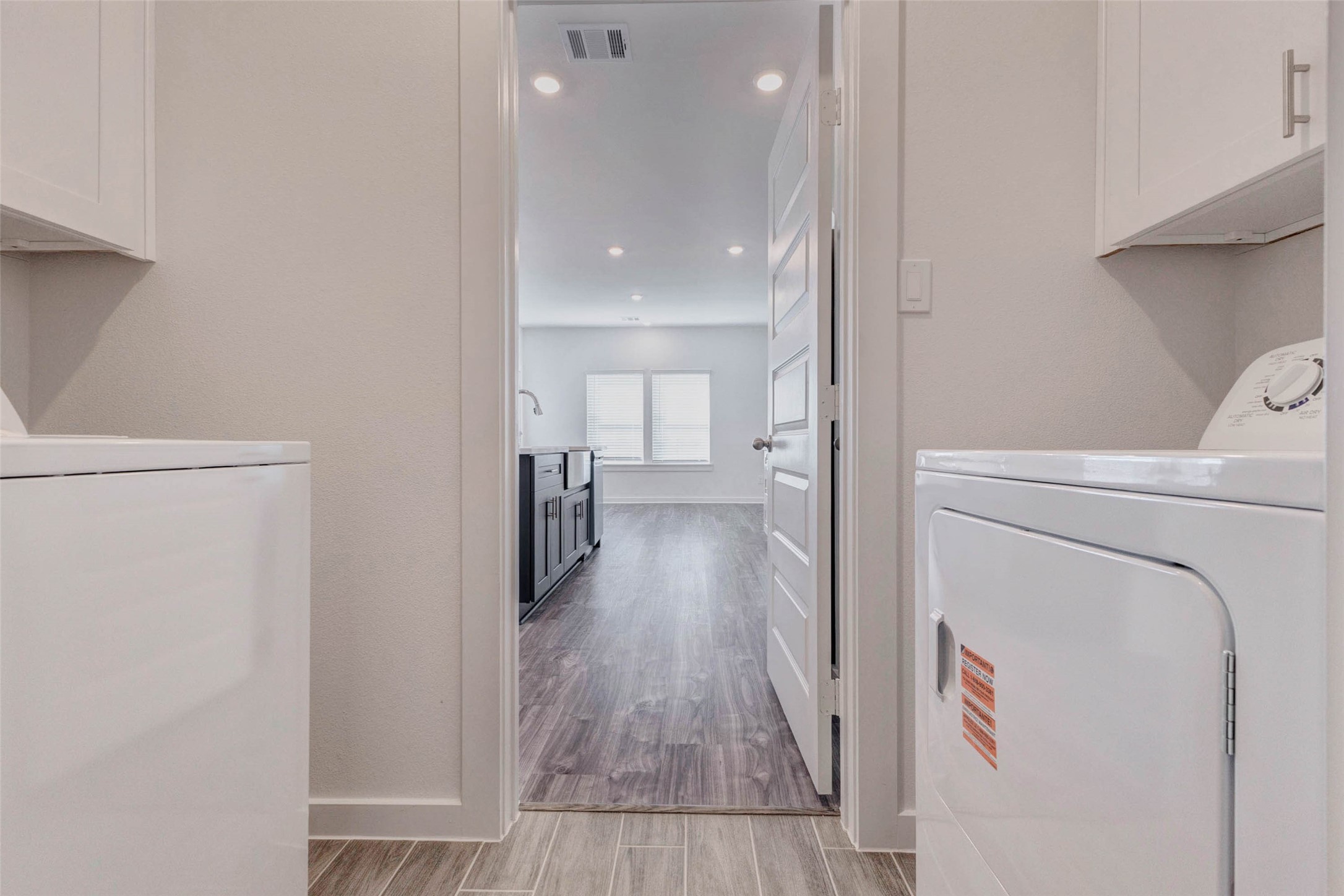 1038 Elsinore Drive Rosharon, TX 77583 - Photo 11 of 27 A convenient in-home utility room provides a dedicated space for laundry with washer and dryer connections and overhead cabinetry for additional storage. Positioned just off the main living area, the layout offers easy access while keeping everyday tasks neatly tucked away. Durable flooring, neutral finishes, and functional design make this laundry space both practical and efficient for maintaining a clean and organized home.