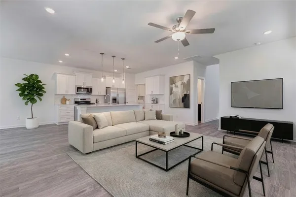 a living room with furniture kitchen view and a potted plant