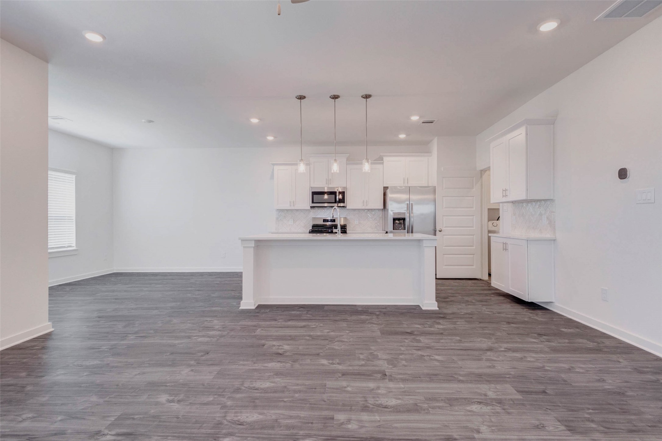 1038 Elsinore Drive Rosharon, TX 77583 - Photo 6 of 27 The heart of the home is this beautifully designed open kitchen and living area, where modern style meets everyday functionality. A large central island with elegant quartz countertops offers ample prep space and casual seating, while pendant lighting adds a touch of sophistication. Stainless steel appliances, sleek cabinetry, and a spacious layout create an ideal setting for cooking, entertaining, and gathering with family and friends.