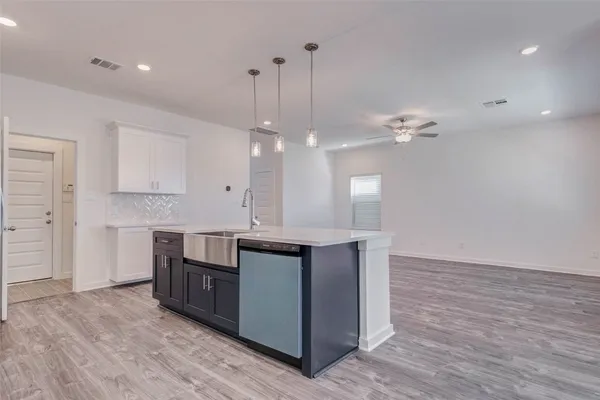 a view of a kitchen with wooden floor and a ceiling fan