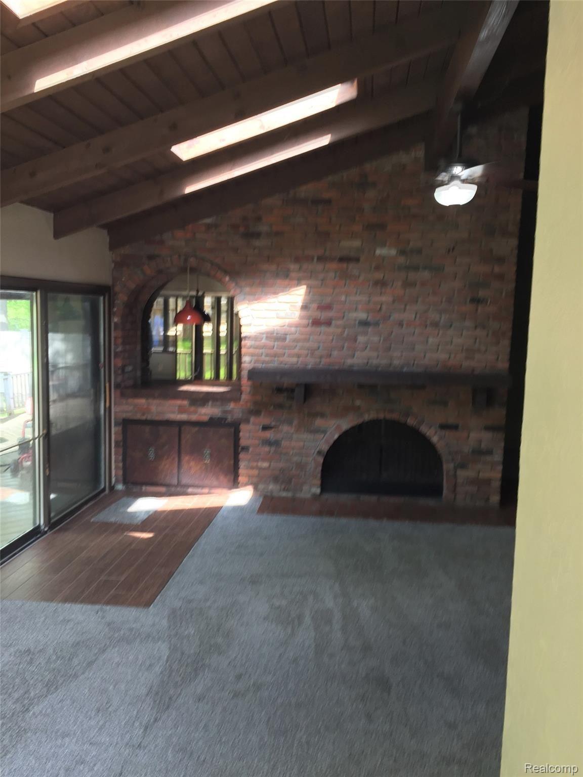 11121 Messmore Road Utica, MI 48317 - Photo 23 of 34 living room double sided fireplace and doorwall to back deck2.jpg