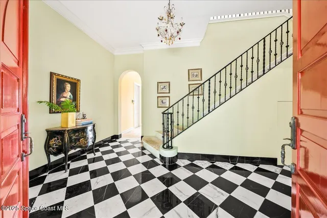a bedroom with a large bed and a chandelier