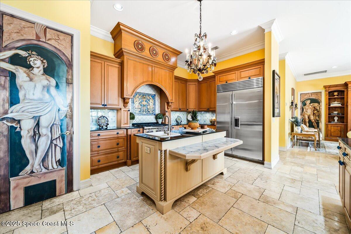 9340 South Tropical Trail Merritt Island, FL 32952 - Photo 23 of 100 a kitchen with stainless steel appliances granite countertop a stove top oven a refrigerator and a chandelier