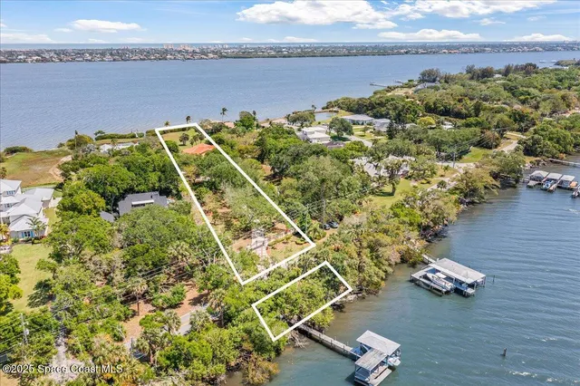 a view of a white house with a yard and plants