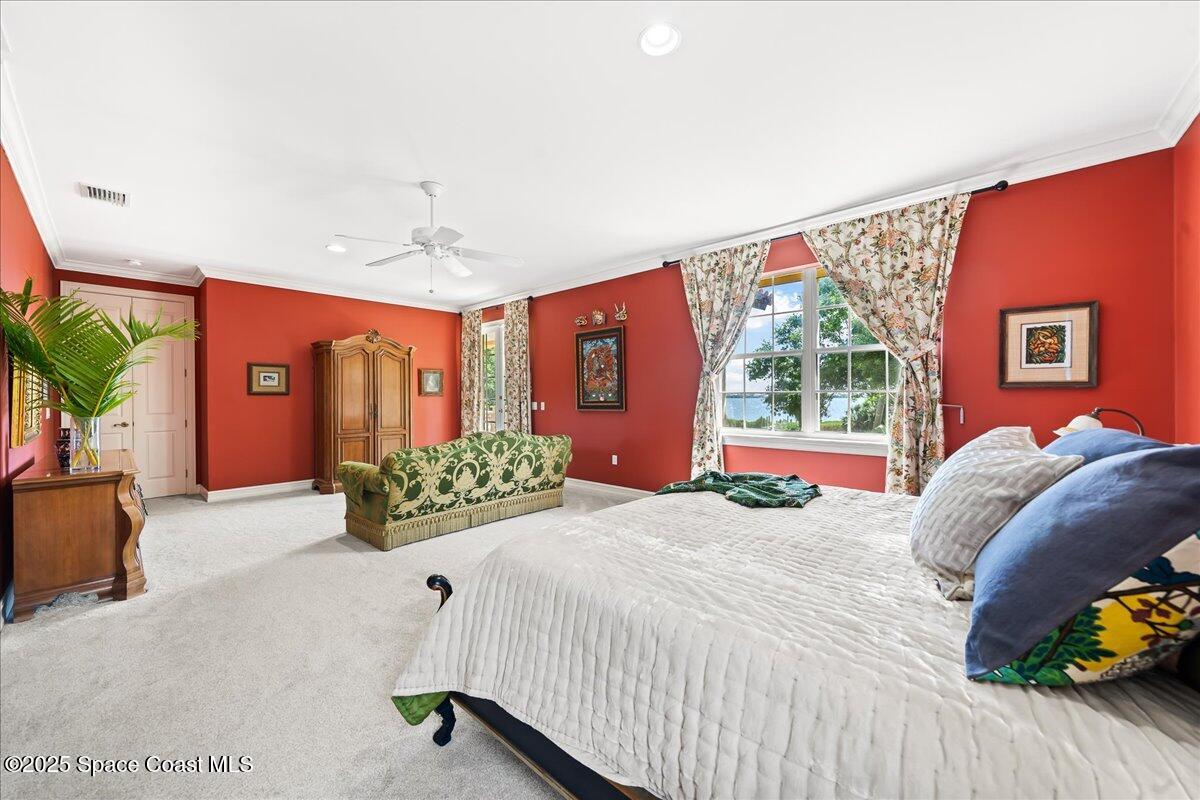 9340 South Tropical Trail Merritt Island, FL 32952 - Photo 41 of 100 a bedroom with a large bed and a chandelier