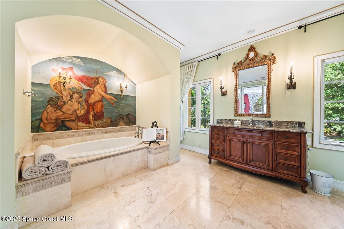 9340 South Tropical Trail Merritt Island, FL 32952 - Photo 45 of 100 a spacious bathroom with a tub sink and mirror