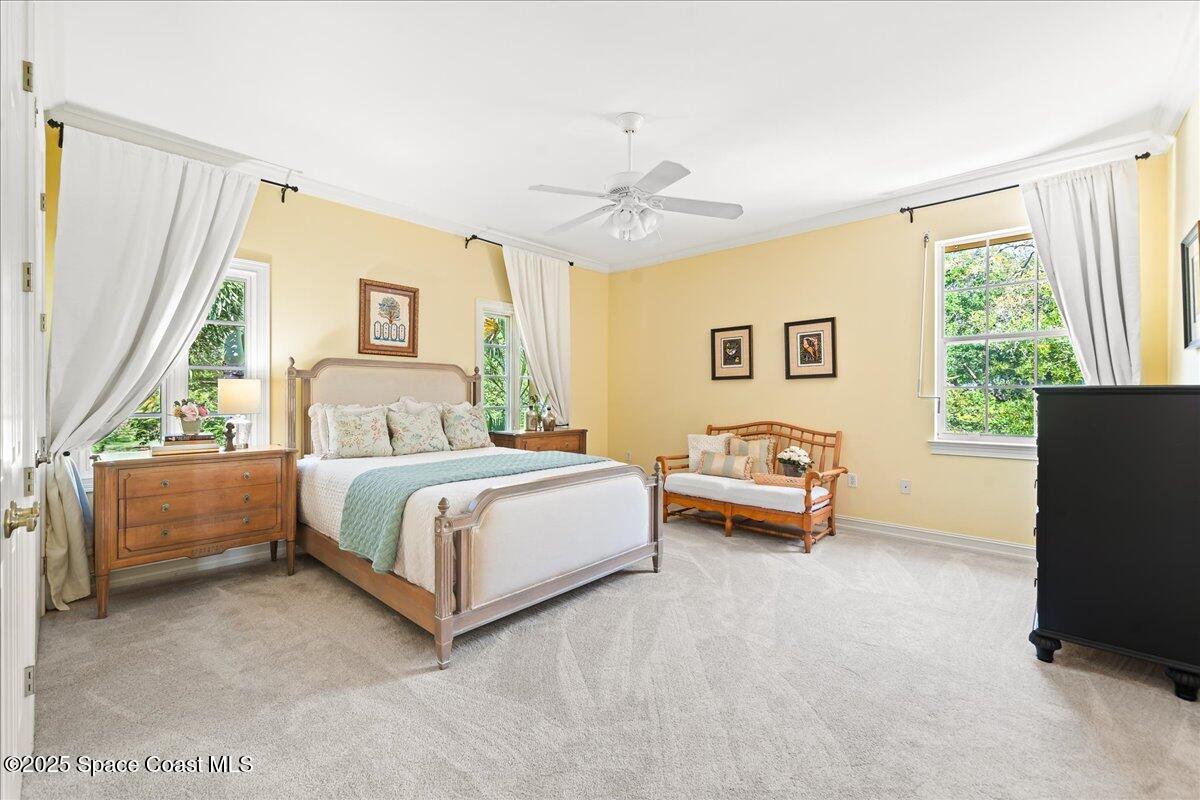 9340 South Tropical Trail Merritt Island, FL 32952 - Photo 50 of 100 a bedroom with a bed and a chandelier