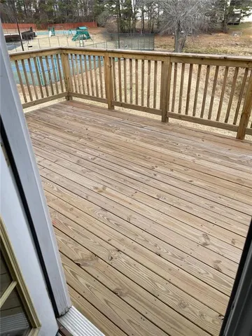an empty room with wooden floor fireplace and windows