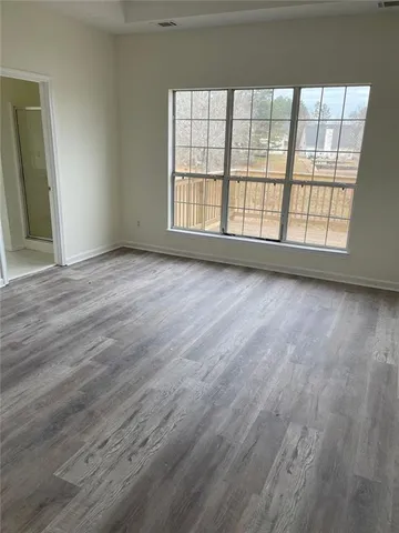an empty room with wooden floor and a window