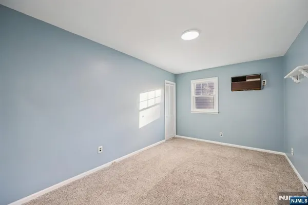 a view of a big room with windows and chandelier fan