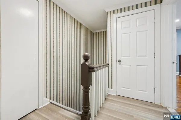 a view of a hallway with wooden floor and entryway