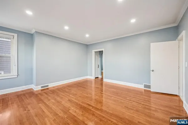 a view of an empty room with wooden floor