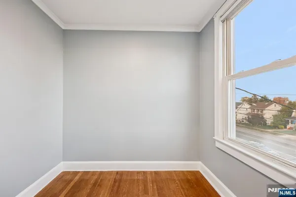 a view of room with window and wooden floor