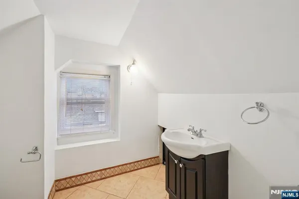 a bathroom with a sink a light fixture and a mirror