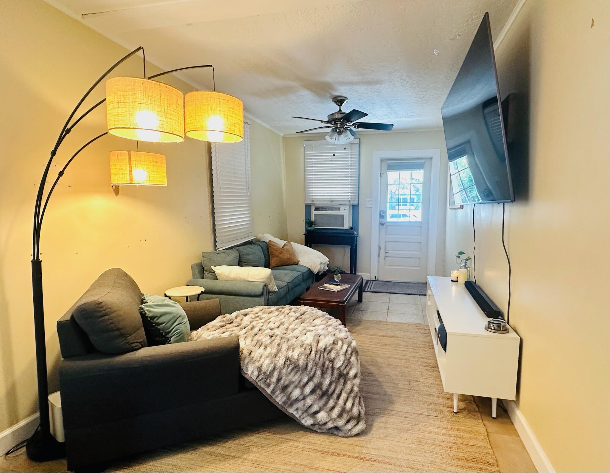 2500 Harris Avenue Key West, FL 33040 - Photo 10 of 22 a living room with couches a flat screen tv and a dining table with painted walls