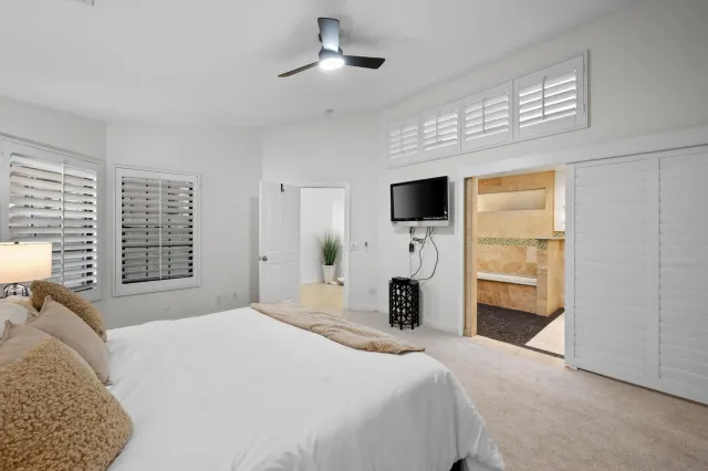 a bedroom with a bed a fireplace and a flat tv screen