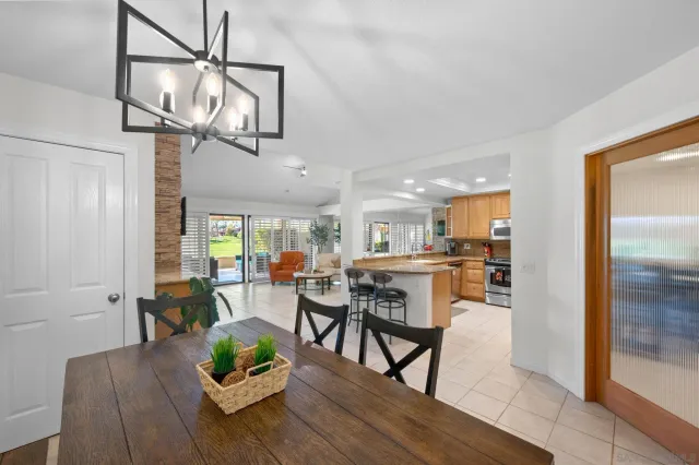a view of a dining room and livingroom with furniture wooden floor a chandelier