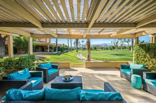 a view of a porch with furniture and a yard