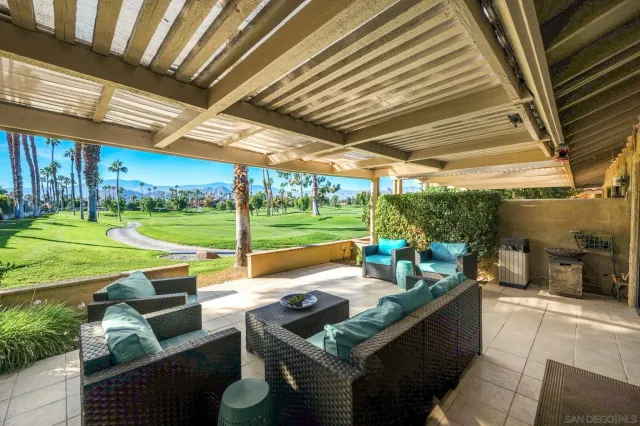 a view of a patio with couches chairs and a backyard