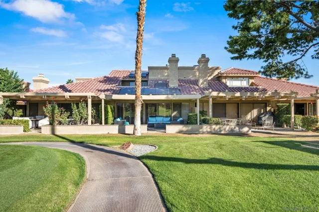 a front view of a house with swimming pool having outdoor seating