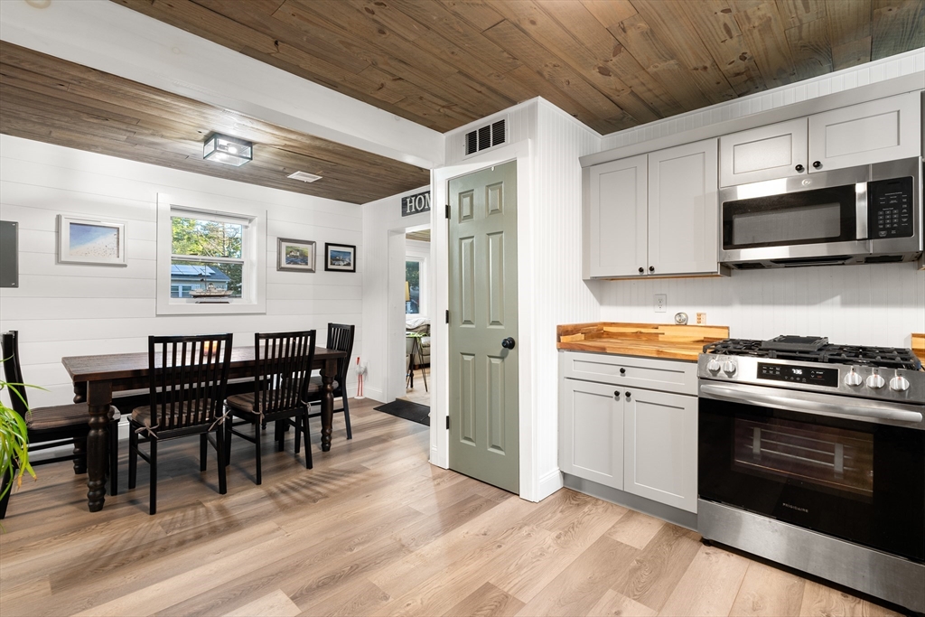25 Lakeview Drive Wareham, MA 02538 - Photo 14 of 31 a kitchen with stainless steel appliances granite countertop a stove a refrigerator a kitchen island a dining table and chairs with wooden floor