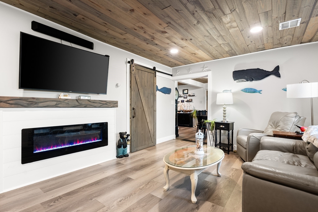 25 Lakeview Drive Wareham, MA 02538 - Photo 10 of 31 a living room with furniture a flat screen tv and a fireplace